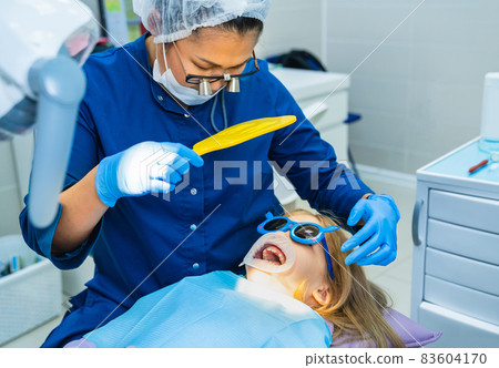 dentist shows in the mirror the cured tooth. Cofferdam for treatment tooth dentist shows in the mirror the cured tooth. Cofferdam for treatment tooth 83604170