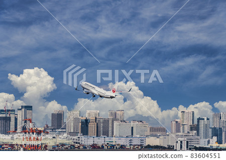 [JAL aircraft taking off from Haneda Airport Terminal 2 and cumulonimbus sky synthesis] 83604551