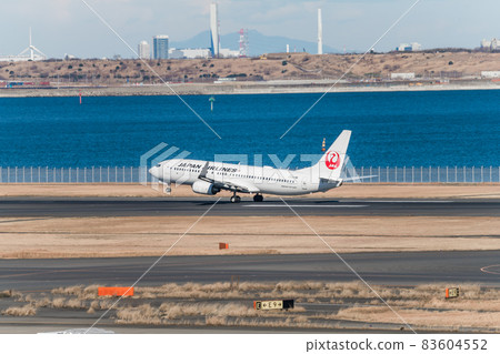 [JAL aircraft taking off from Haneda Airport Terminal 2 in the background of Tokyo Bay] 83604552