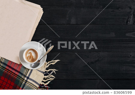 Workspace with newspaper, coffee cup, scarf. Stylish office desk. Autumn or Winter concept. Flat lay, top view Workspace with newspaper, coffee cup, scarf. Stylish office desk. Autumn or Winter concept. Flat lay, top view 83606599