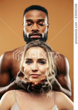 Young pretty couple diverse races together posing sensitive on brown background, lifestyle people concept 83608306