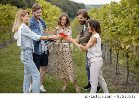 Friends tasting wine near vineyards in countryside 83610512