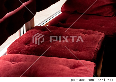 Red velvet pillows on a bench closeup 83610653