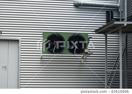 Large industrial air conditioning on a building wall 83610806