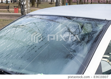 Glass of gray car with hoarfrost closeup 83610807
