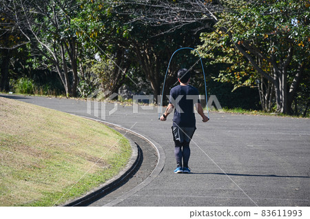 A man jumping rope in the park A man jumping rope in the park 83611993