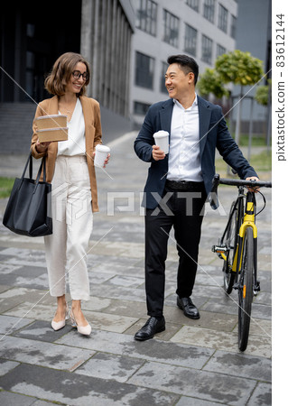 Business people walk, drink coffee and talk 83612144