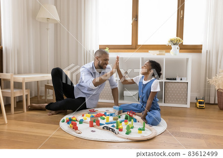 Joyful african american father giving high five to daughter. 83612499