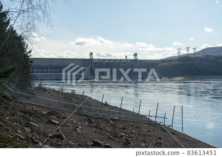Rocky river bank against the background of the hydroelectric power station. 83613451
