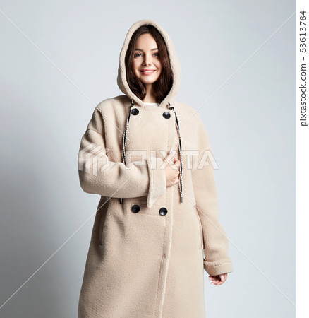 Happy young woman wearing a fur. beautiful smiling girl in Hoodie coat 83613784