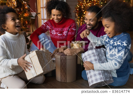Excited biracial family unpack Christmas gifts together 83614774