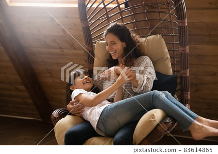 Happy joyful mom tickling, cuddling excited daughter girl Happy joyful mom tickling, cuddling excited daughter girl 83614865