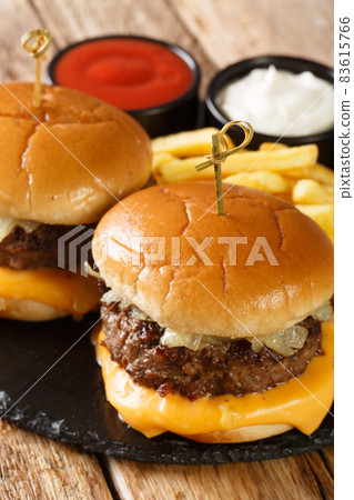 Classic butter burgers with fries and sauces close-up on a slate board. vertical Classic butter burgers with fries and sauces close-up on a slate board. vertical 83615766