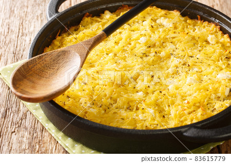 Delicious casserole Patatnik made from potatoes with onions, cheese and eggs close-up in a frying pan. horizontal Delicious casserole Patatnik made from potatoes with onions, cheese and eggs close-up in a frying pan. horizontal 83615779