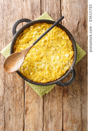 Patatnik or patetnik is a traditional Bulgarian potato based dish prepared with grated potatoes bryndza onions, as well as spearmint close-up. Vertical top view Patatnik or patetnik is a traditional Bulgarian potato based dish prepared with grated potatoes bryndza onions, as well as spearmint close-up. Vertical top view 83615783