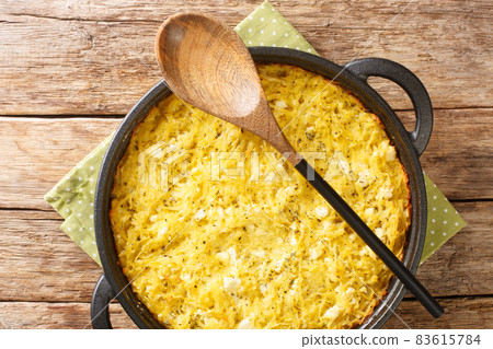 Delicious casserole Patatnik made from potatoes with onions, cheese and eggs close-up in a frying pan. horizontal top view Delicious casserole Patatnik made from potatoes with onions, cheese and eggs close-up in a frying pan. horizontal top view 83615784