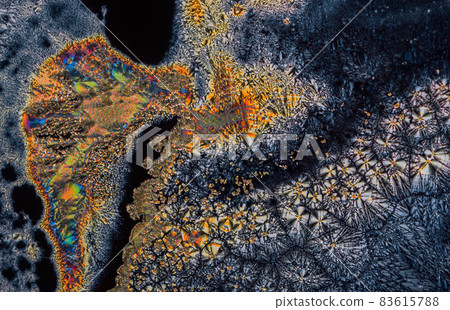 Extreme macro photograph of Vitamin C crystals forming abstract modern art patterns, when illuminated with polarized light, under a microscope objective with 10x magnification 83615788