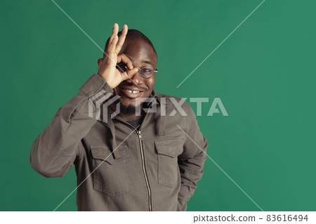 One young stylish african man wearing casual clothes isolated on dark green studio background. Emotions, facial expression concept. 83616494