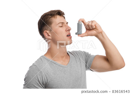 Calm concentrated millennial caucasian attractive male suffering from asthma and spraying inhaler in mouth Calm concentrated millennial caucasian attractive male suffering from asthma and spraying inhaler in mouth 83616543