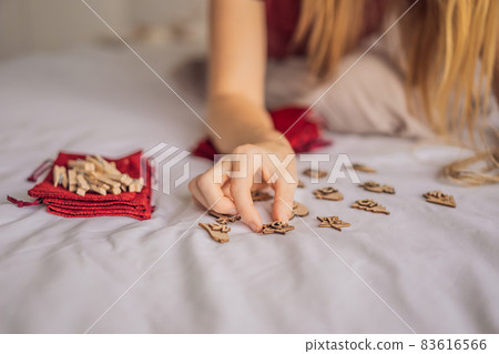 Woman making Christmas advent calendar. Pouches on a rope 83616566