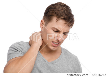 Unhappy millennial caucasian attractive guy presses hands to sore spot and suffers from neck pain Unhappy millennial caucasian attractive guy presses hands to sore spot and suffers from neck pain 83616764