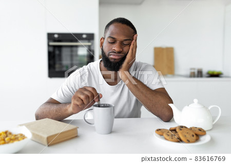 Black man suffering from insomnia drinking coffee Black man suffering from insomnia drinking coffee 83616769