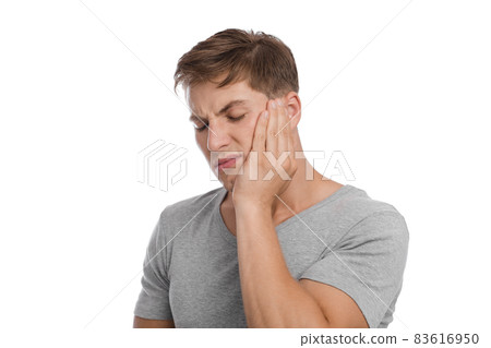 Unhappy sad millennial caucasian man presses hand to cheek and suffers from toothache 83616950