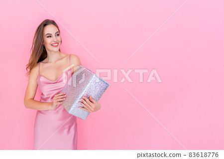 Happy Young smiling girl holds gift box on isolated pink studio background. Celebration concept  83618776