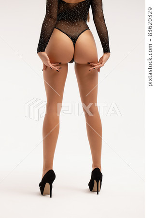 Seductive woman wearing black bodysuit and high heels 83620329