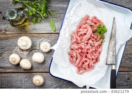 Raw veal strips for traditional Swiss zurcher geschnetzeltes with herbs Raw veal strips for traditional Swiss zurcher geschnetzeltes with herbs 83621279