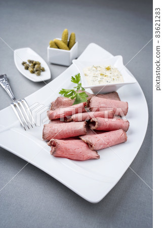 Traditional lunch meat with sliced cold cuts roast beef and remoulade  83621283