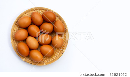 Chicken eggs in round bamboo basket on white. Chicken eggs in round bamboo basket on white. 83621952