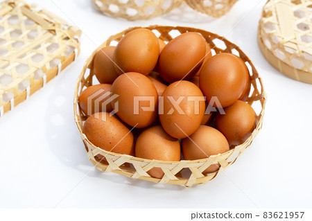 Chicken eggs in bamboo basket on white. Chicken eggs in bamboo basket on white. 83621957