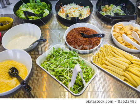 The variety mix of the vegetables and ingredients of the salad bar. The variety mix of the vegetables and ingredients of the salad bar. 83622485