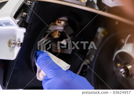 Cleaning of ion source of mass spectrometer by laboratory worker in rubber gloves. LC MS, liquid chromatography and daily routine  83624957