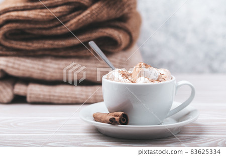 Cup of cacao and pile of knitwear Cup of cacao and pile of knitwear 83625334
