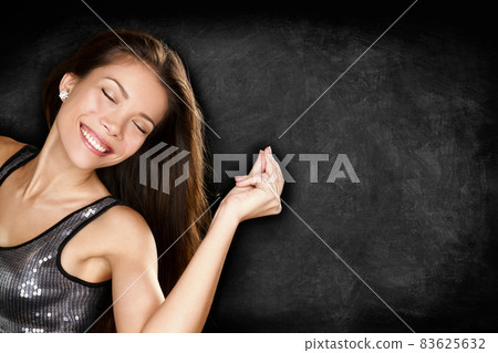 Music woman dancing having fun snapping fingers to song partying in nightclub party with blackboard texture for text copy space advertising. Club young people lifestyle. Music woman dancing having fun snapping fingers to song partying in nightclub party with blackboard texture for text copy space advertising. Club young people lifestyle. 83625632