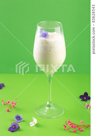 milk shake white cocktail in glass with berries and flowers 83626543