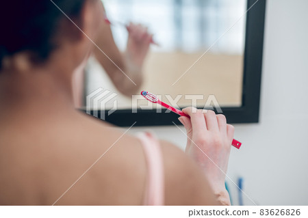 A close up of a woman with a tooth brush in hands 83626826