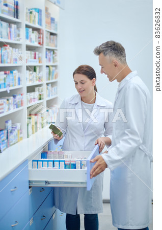 Man and woman in white coats with medicines Man and woman in white coats with medicines 83626832