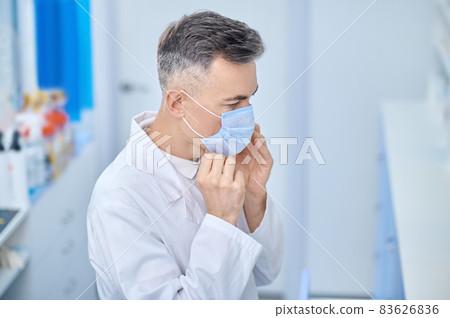 Confident in lab coat and protective mask Confident in lab coat and protective mask 83626836