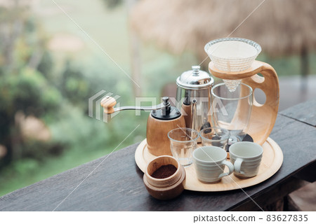 A drip coffee set with a Steel kettle, glass, and hand drip coffee maker in minimalist style. A drip coffee set with a Steel kettle, glass, and hand drip coffee maker in minimalist style. 83627835