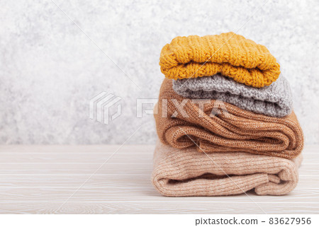 Pile of warm knitted clothes copy space 83627956