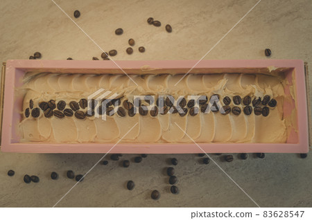 Preparation of handmade soap. The base for soap in silicone form, decorated with coffee beans. Top view, horizontal composition, copy space, color toning Preparation of handmade soap. The base for soap in silicone form, decorated with coffee beans. Top view, horizontal composition, copy space, color toning 83628547