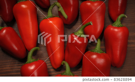 Close up chillies or peppers and capsicums or bell peppers. sweet bell, paprika, cayenne, chilli, hungarian wax pepper, isolated on wooden table background Close up chillies or peppers and capsicums or bell peppers. sweet bell, paprika, cayenne, chilli, hungarian wax pepper, isolated on wooden table background 83628894