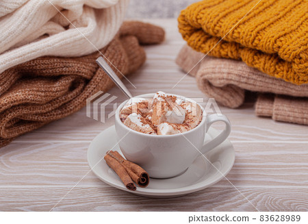 Cup of cacao and pile of knitwear 83628989