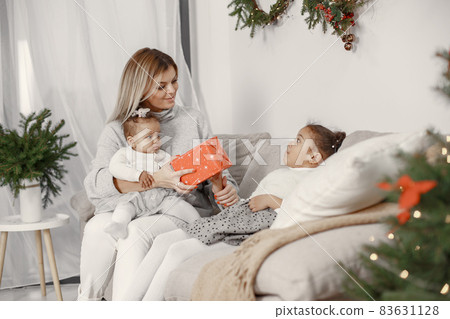 Caucasian mother with two little african daughters at home Caucasian mother with two little african daughters at home 83631128