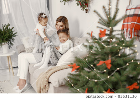 Caucasian mother with two little african daughters at home Caucasian mother with two little african daughters at home 83631130