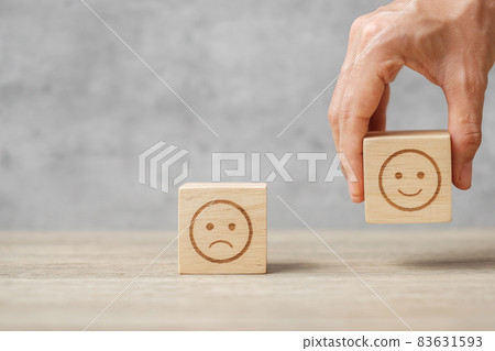 hand holding smile face block. Customer choose Emoticon for user reviews. Service rating, ranking, customer review, satisfaction, mood, mental health and feedback concept hand holding smile face block. Customer choose Emoticon for user reviews. Service rating, ranking, customer review, satisfaction, mood, mental health and feedback concept 83631593