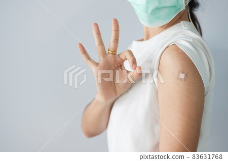 woman showing OK sign with bandage after receiving covid 19 vaccine. Vaccination, herd immunity, side effect, booster, vaccine passport and Coronavirus pandemic woman showing OK sign with bandage after receiving covid 19 vaccine. Vaccination, herd immunity, side effect, booster, vaccine passport and Coronavirus pandemic 83631768